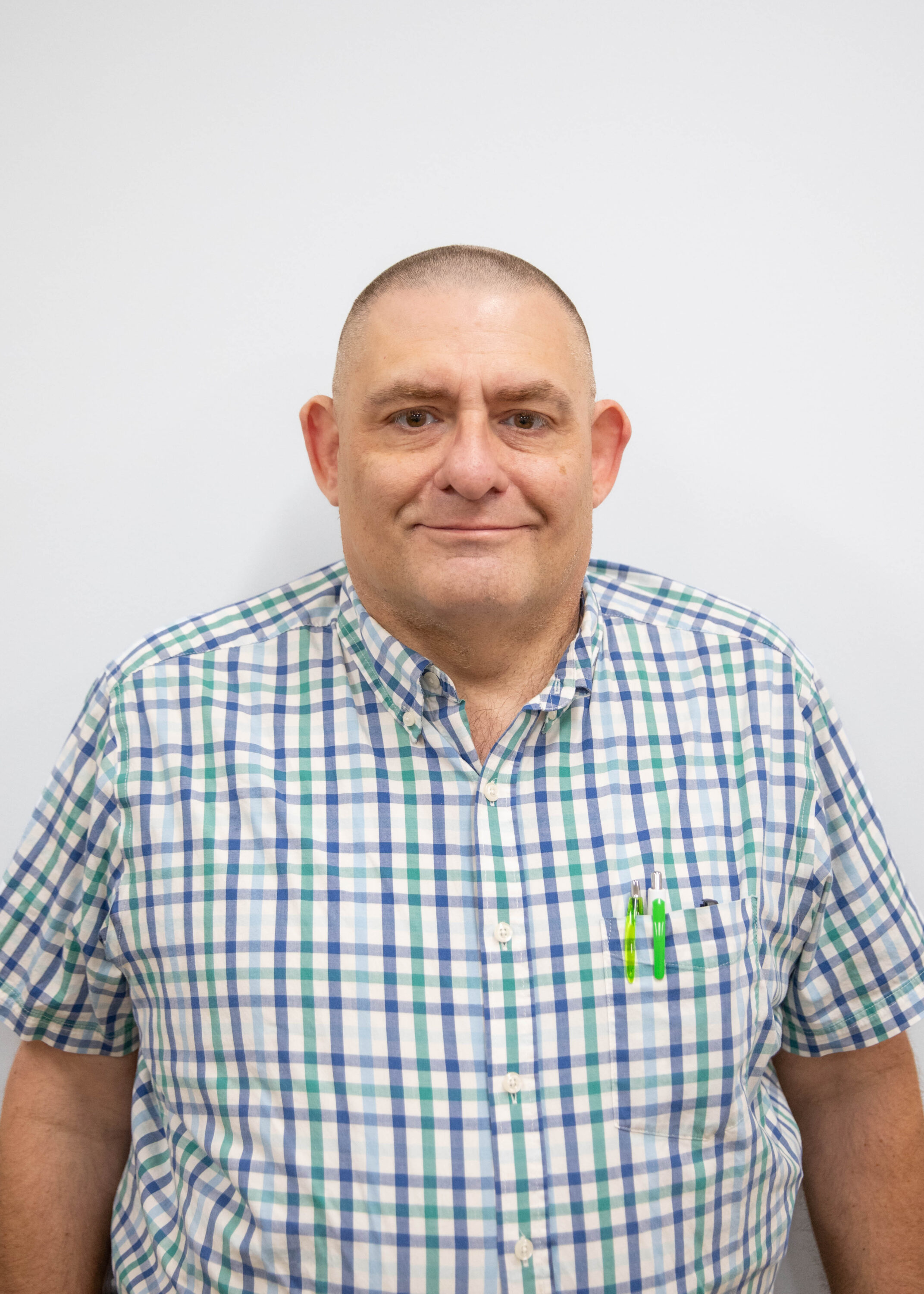 Man in plaid shirt with pens in pocket