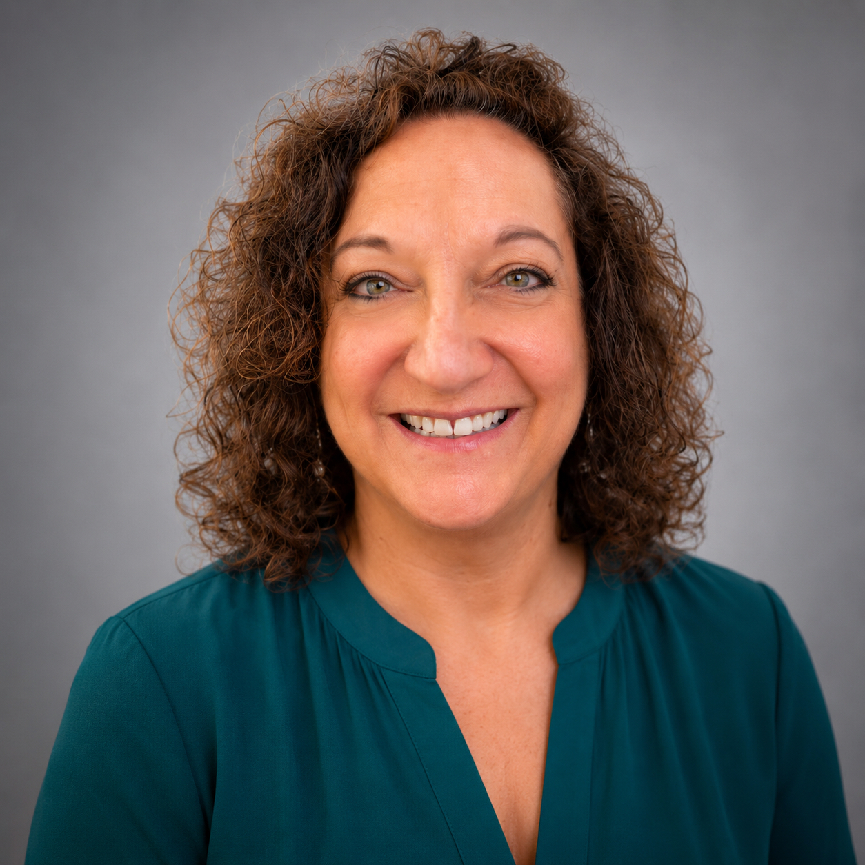 Smiling woman with curly hair in green blouse