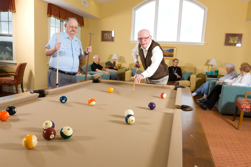 Seniors playing pool in community lounge