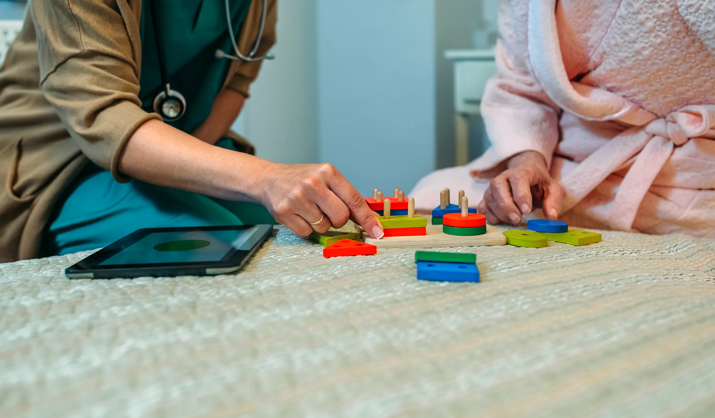 Healthcare worker assisting senior with wooden puzzle