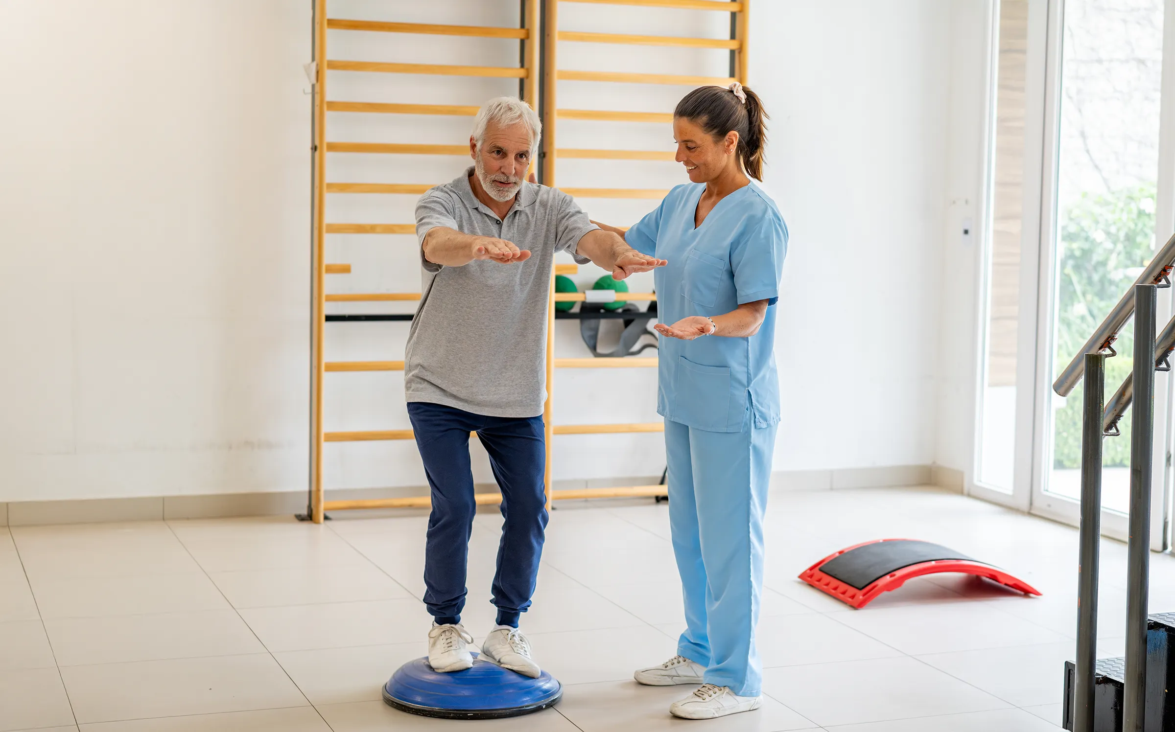Senior man doing balance exercise with therapist