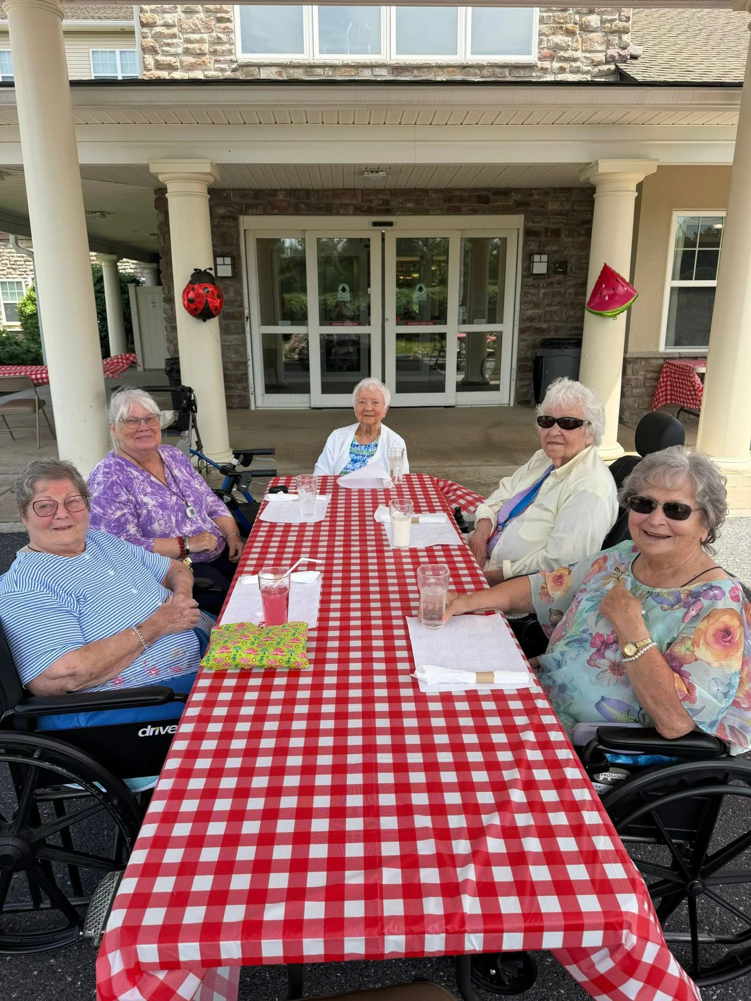 Five elderly women at outdoor picnic table