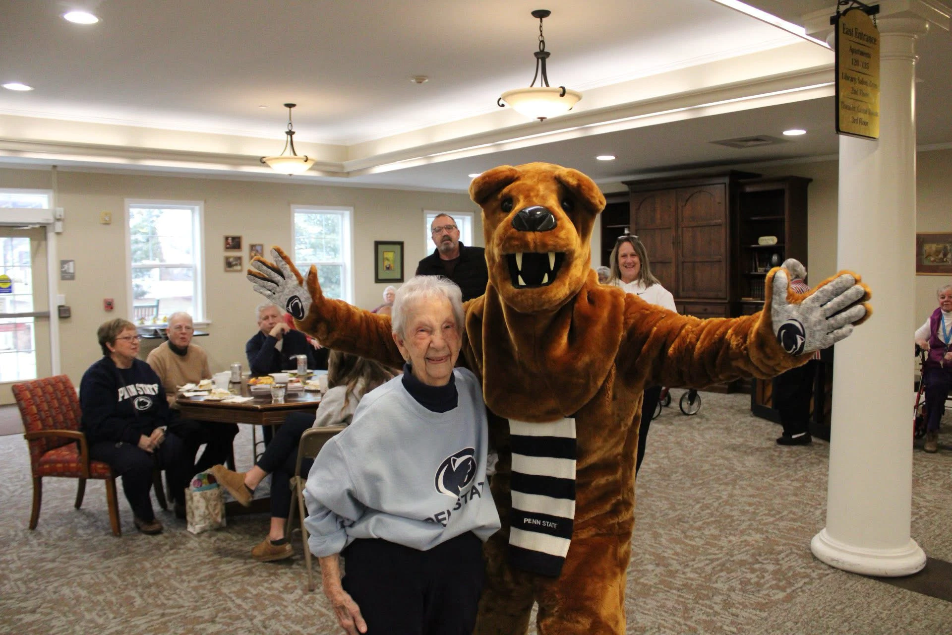 Penn State mascot posing with elderly woman indoors